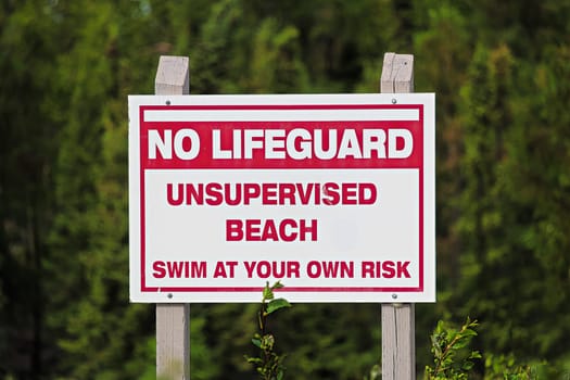 A no lifeguard unsupervised beach use at own risk sign.