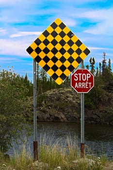 A checkered no entry and stop sign in both english and french.
