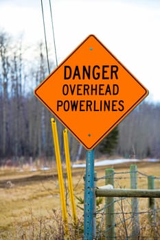 Danger overhead powerline sign beside a driveway.