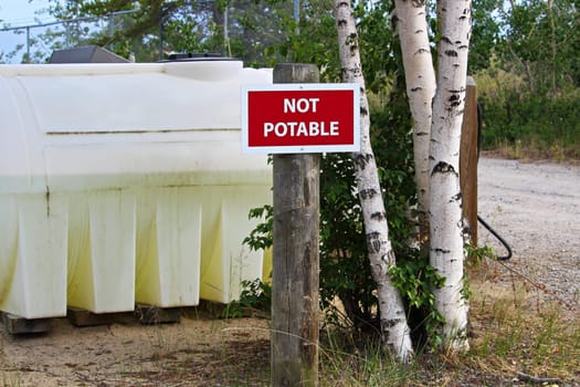 A not potable sign next to a water holding tank.
