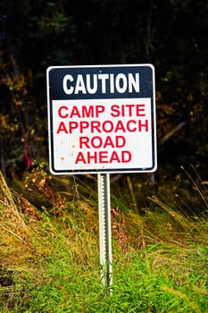 A Caution Camp Site Approach Road Ahead sign.