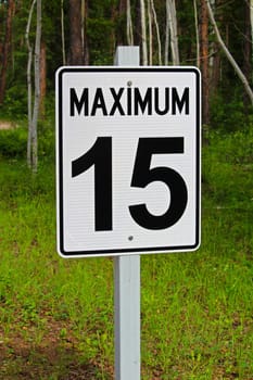 An angled view of a maximum 15 speed limit sign.