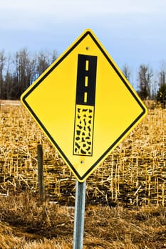 End of gravel road ahead warning sign.