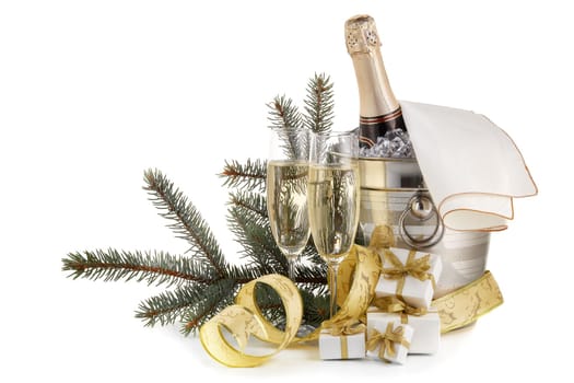 Still life with champagne bottle standing in a bucket with ice, two full champagne flutes and Christmas ornaments isolated on a white background with copy space, Christmas and New Year celebration