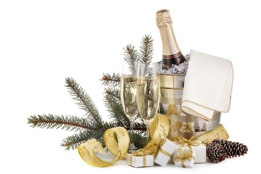 Still life with champagne bottle standing in a bucket with ice, two full champagne flutes and Christmas ornaments isolated on a white background with copy space, Christmas and New Year celebration