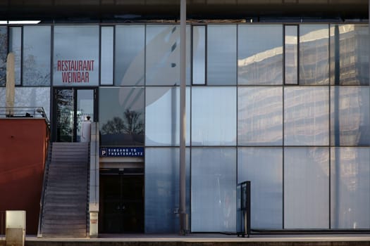 Aschaffenburg, Germany - November 17, 2018: The modern glass facade of the Municipal Theater Aschaffenburg with the entrance to a wine bar and a restaurant on November 17, 2018 Aschaffenburg..