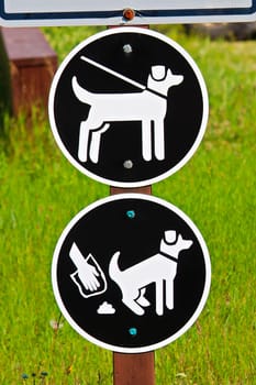 A keep pets on leash and pickup poop sign.