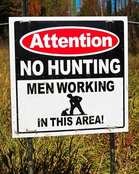 An attention no hunting, men working sign.