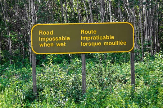 A bilingual road impassable when wet sign.