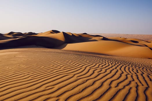 Sand dunes in desert landscape. Wahiba Sands, Sultanate of Oman.