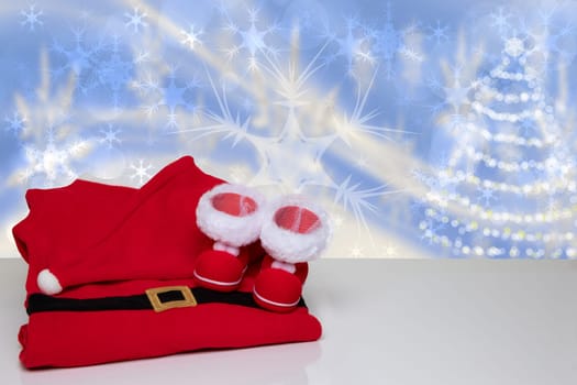 Christmas background. Table top christmas winter decoration background with Santa Claus costume and Santa boots on bright table with space over abstract festive blue christmas compostion.