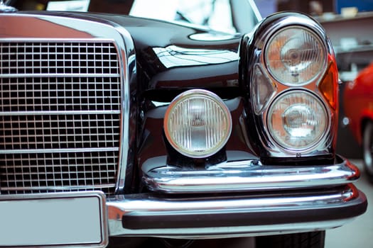 Classic vintage car. Close-up of headlights of luxurious vintage vehicle