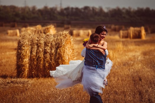 bride and groom near hay barn