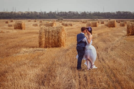 bride and groom near hay barn