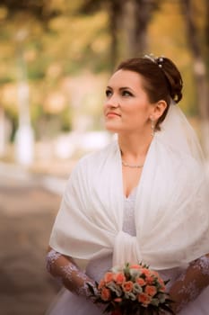 Beautiful bride in wedding dress and bridal bouquet, happy newlywed woman with wedding flowers, woman with wedding makeup and hairstyle. gorgeous young bride outdoors. Bride waiting for groom. bride