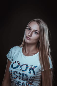 Portrait of a young girl with clean skin on a black background close-up.