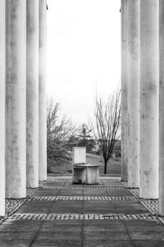Cement Columns Chair Rough Texture Perspective Overhead Grid Geometric Pattern Design Outdoor Park Public Upright Minimal Bright Stone