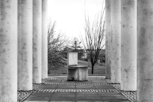 Cement Columns Chair Rough Texture Perspective Overhead Grid Geometric Pattern Design Outdoor Park Public Upright Minimal Bright Stone
