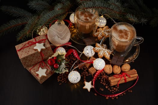 Still life with two cups of coffee, gingerbread cookies, gift box and Christmas decorations on a dark background with LED lights garland . Christmas and New Year treat. Top view