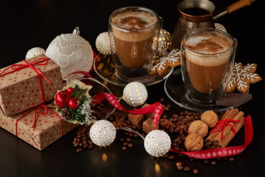 Still life with two cups of coffee, gingerbread cookies, gift box and Christmas decorations on a dark background with LED lights garland . Christmas and New Year treat.