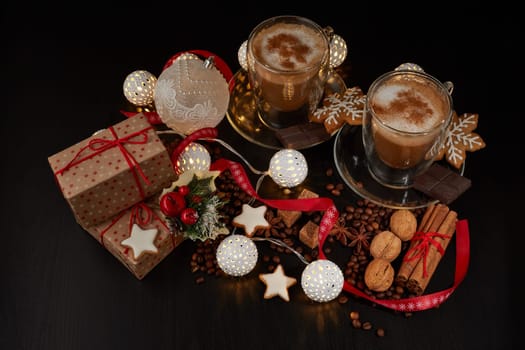 Still life with two cups of coffee, gingerbread cookies, gift box and Christmas decorations on a dark background with LED lights garland . Christmas and New Year treat. Top view