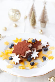 Star-shaped ice cream with cinnamon cookies, blueberries and persimmon