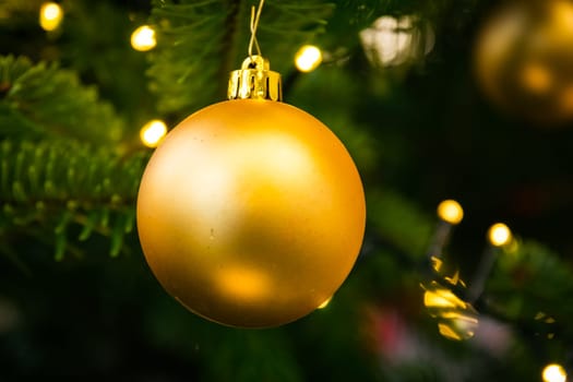 Christmas Tree Ball Ornament Festive Holiday Decoration Gold Closeup Depth of Field Bokeh Centered
