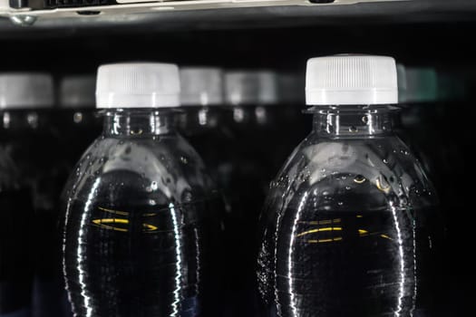 Soda Bottles in Vending Machine White Bottle Caps Black Liquid Rows