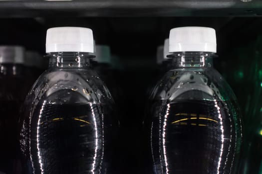 Soda Bottles in Vending Machine White Bottle Caps Black Liquid Rows