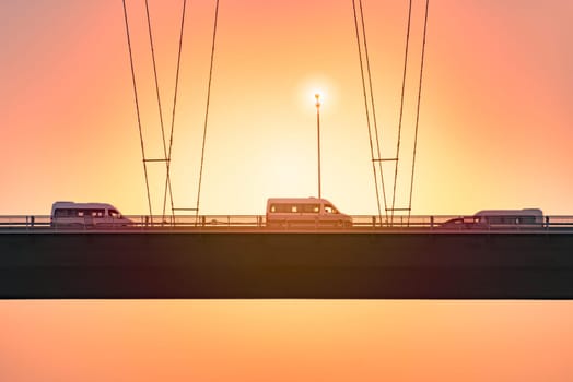 Cars on Bosphorus Bridge known officially as the 15 July Martyrs Bridge is one of the three suspension bridges spanning the Bosphorus strait in Istanbul, Turkey. Sunset sky in background.