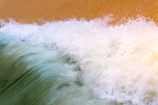 Ocean Wave Crashing on Sandy Beach Foam