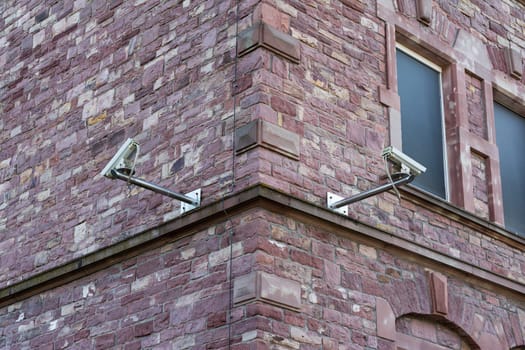 Two Security Cameras on Brick Wall Corner Security Change Architecture