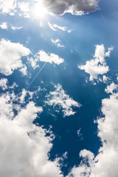 White Clouds Blue Sky Fluffy Sun Flare Airplane Trail  Sunny Daytime Texture Background