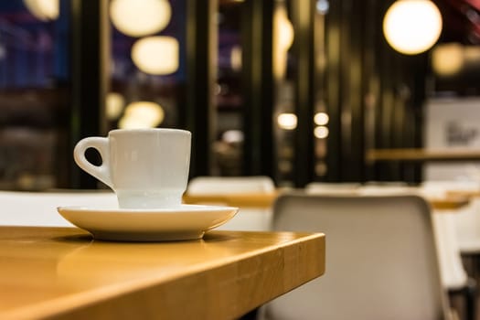 Small White Espresso Cup and Saucer on Table in Chic Retro Cafe Morning