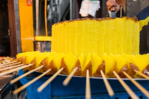 Sweet Brightly Colored Yellow Cake at Traditional Chinese Market with Sticks
