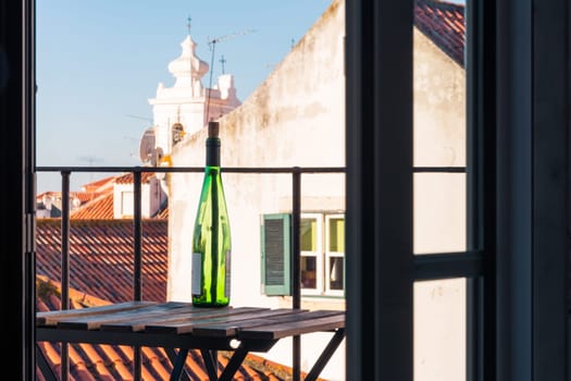 Empty Wine Bottle on Wooden Balcony Table over Alfama European Vacation Beautiful Day Relaxing