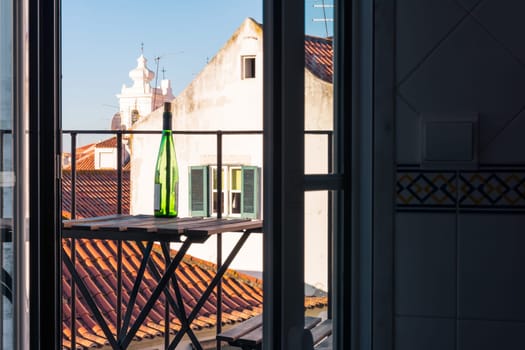 Empty Wine Bottle on Wooden Balcony Table over Alfama European Vacation Beautiful Day Relaxing