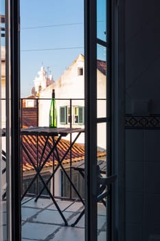 Empty Wine Bottle on Wooden Balcony Table over Alfama European Vacation Beautiful Day Relaxing