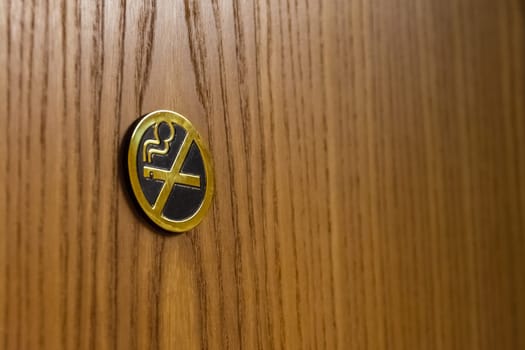 Golden Metal No Smoking Sign on Brown Wooden Door Hotel