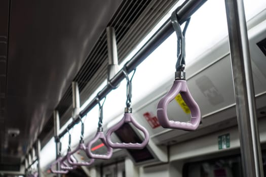 Hand Grips Row on Subway Under Flourescent Light Asian Subway