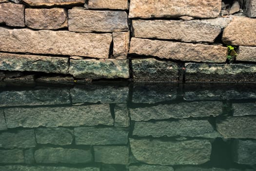 Bricks on Waterside and its Inverted Reflection in Water