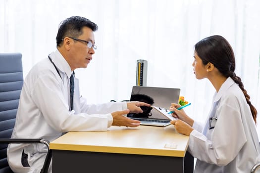 Two doctors in the hospital discuss the diagnos of the patient