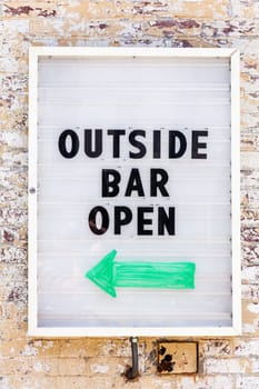 Sign on the wall reading: Outside Bar Open