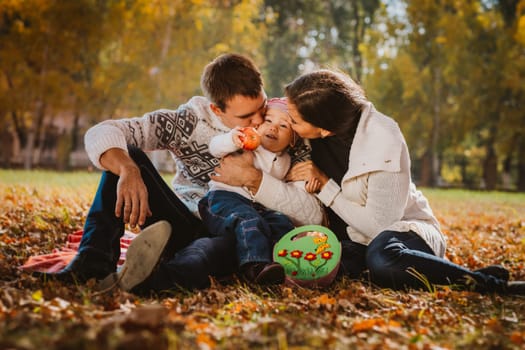 Happy mother, father and daughter in the park