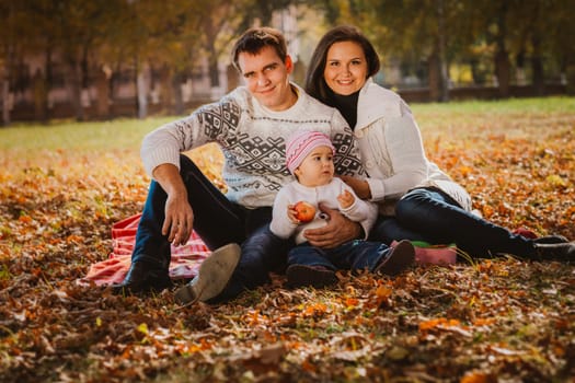 Happy mother, father and daughter in the park