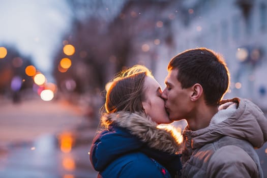 Portrait of young beautiful couple kissing in an autumn rainy day. Love and couple relationships concept.