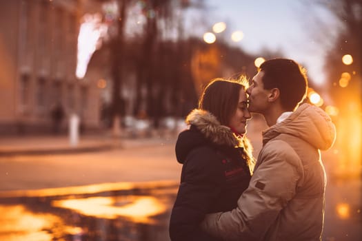 Portrait of young beautiful couple kissing in an autumn rainy day. Love and couple relationships concept.