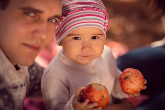 happy young family spending time outdoor in the autumn park