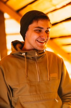 Man hipster wearing waxed canvas jacket with village backhround