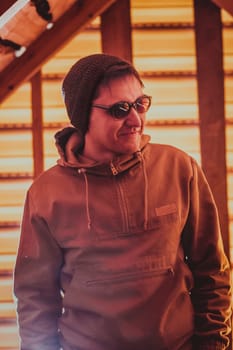 Man hipster wearing waxed canvas jacket with village backhround